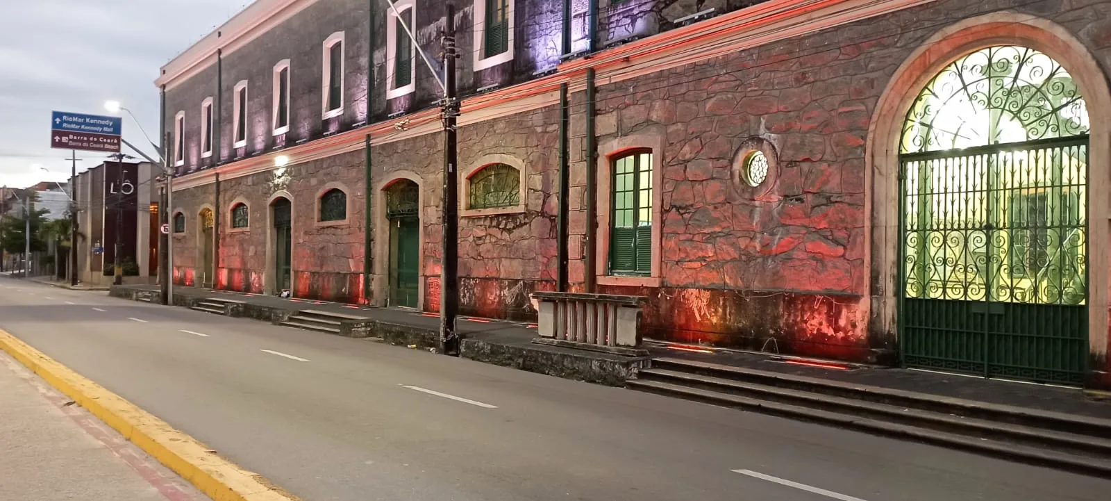 Fachada histórica restaurada da Caixa Cultural de Fortaleza, com portão em arco iluminado